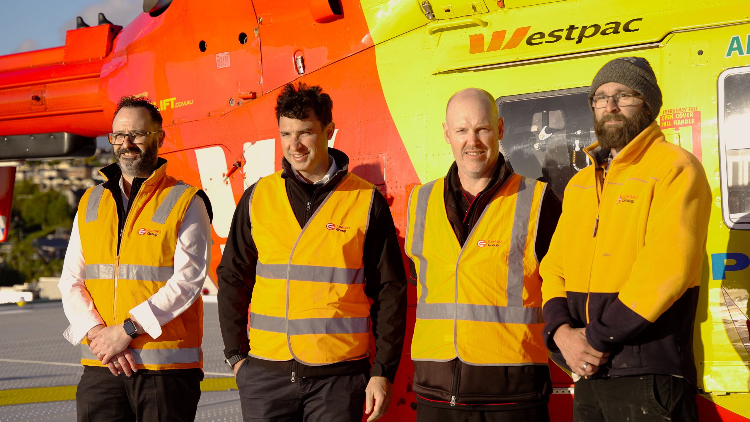 Contact Group Managers standing in front of helicopter.